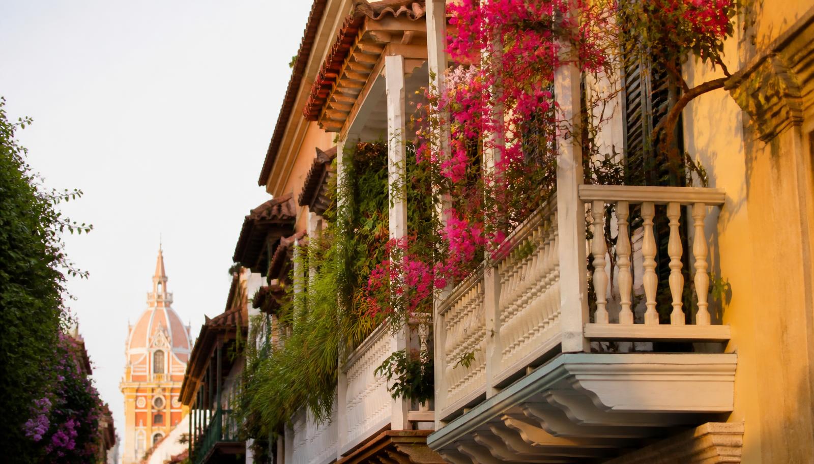 Calle colonial de colores con buganvilias en Cartagena, Colombia